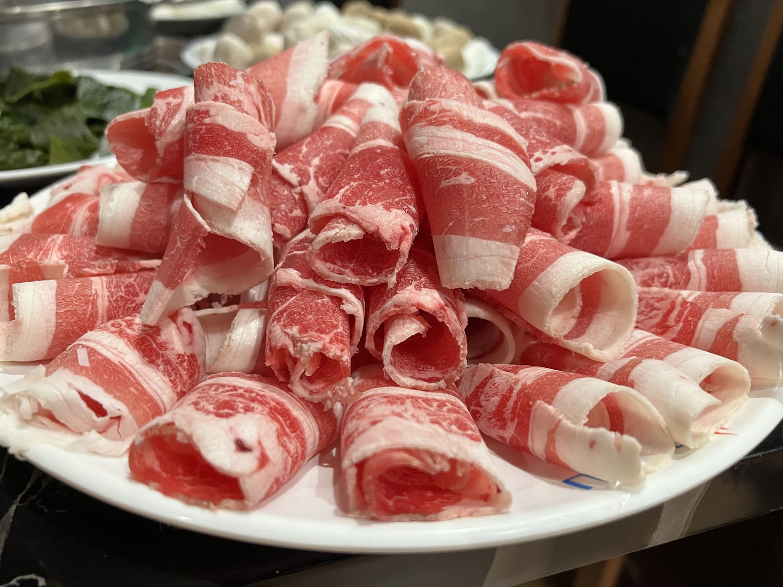 Thin-sliced beef rolls piled high, ready for the grill or hot pot