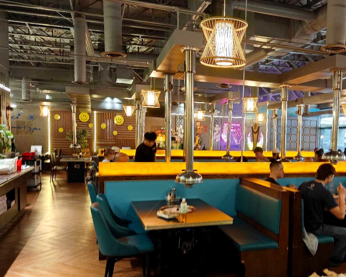 Inside Ombu Grill Orem: teal booths, table-side grills and rattan lanterns
